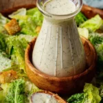 A bowl of high protein Caesar dressing with fresh ingredients and a green salad