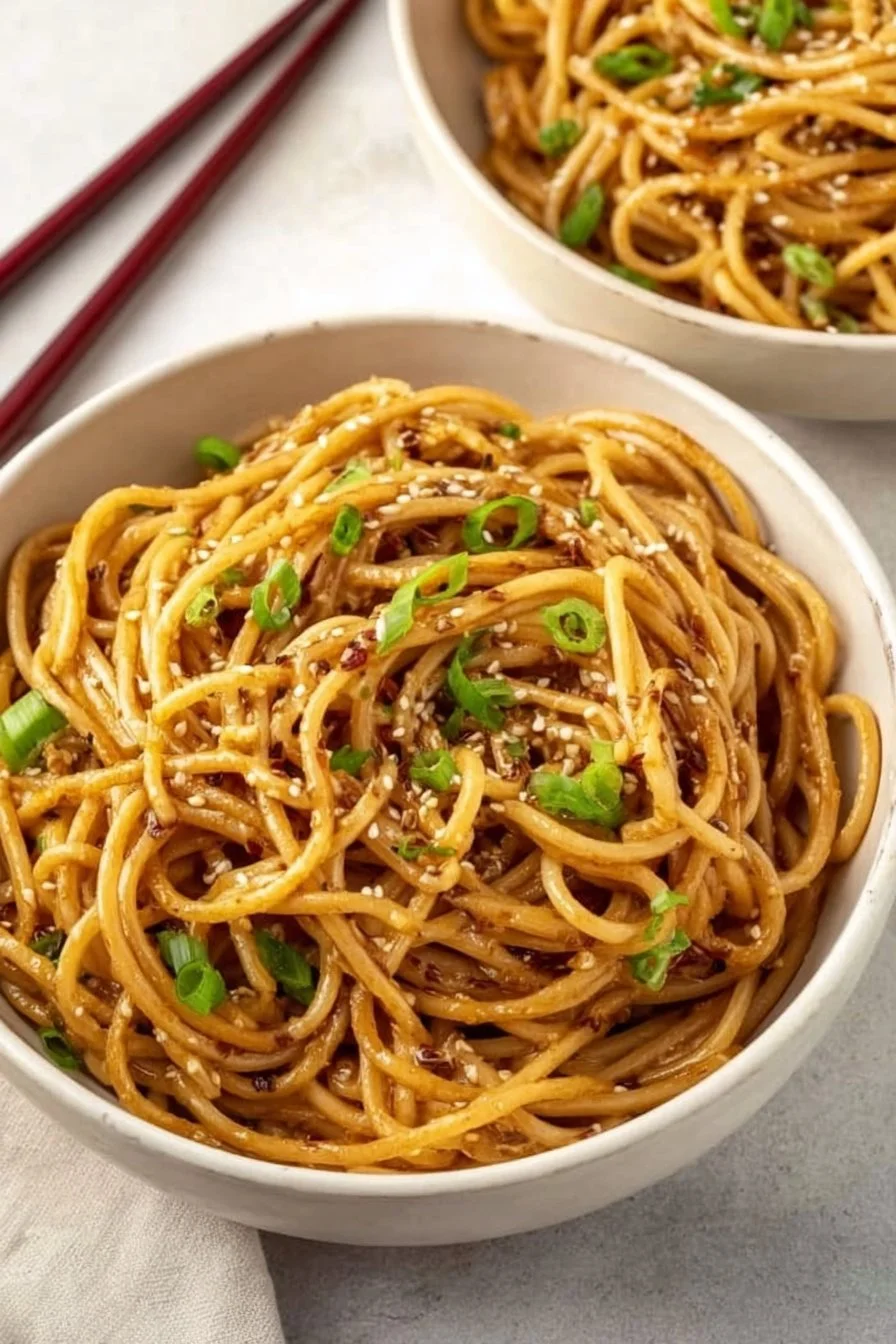 Delicious Garlic Sesame Noodles served in a bowl garnished with sesame seeds.
