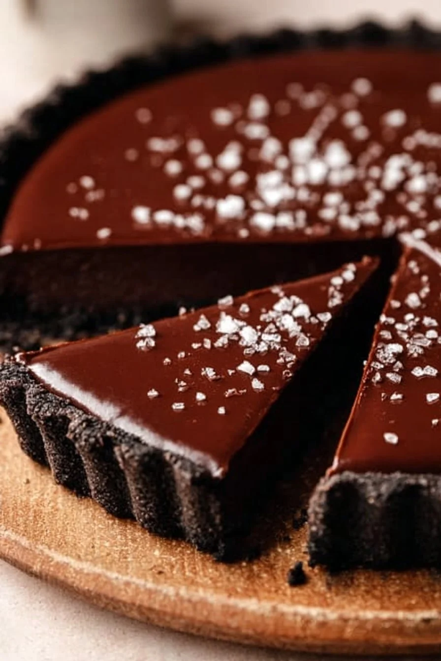 No-bake vegan chocolate tart topped with fresh fruit and nuts