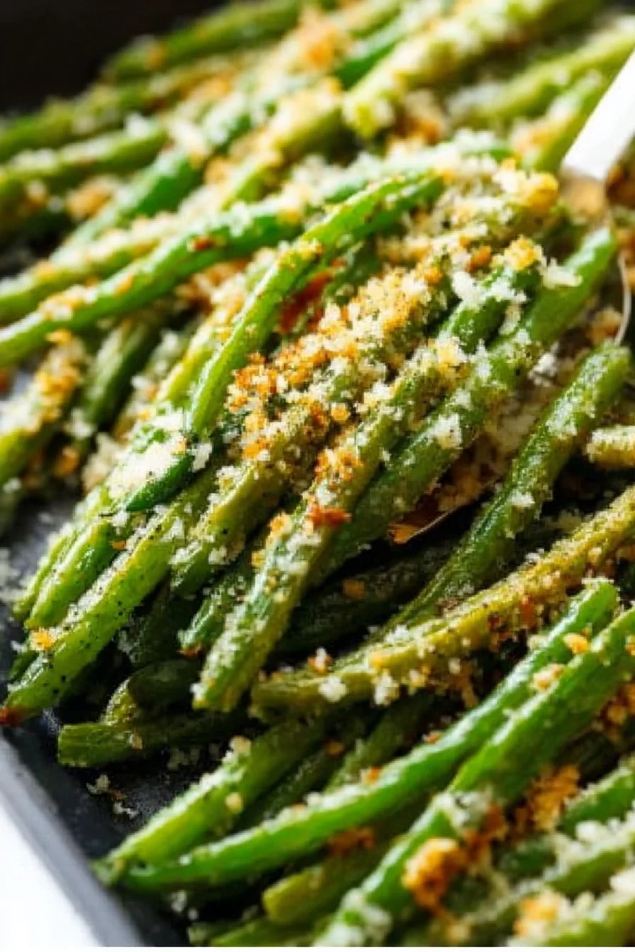Bowl of roasted Parmesan green beans garnished with herbs