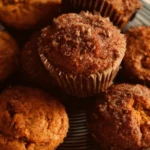 Freshly baked sweet potato muffins on a wooden table.
