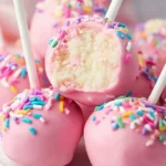 Delicious vegan cake pops decorated with colorful sprinkles on a white plate