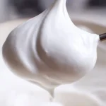 Bowl of fluffy Vegan Marshmallow Fluff with a spoon