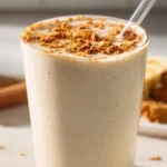Delicious banana bread protein shake in a glass with banana slices and oats.