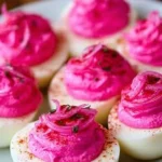 Delicious pickled onion deviled eggs garnished with herbs on a plate