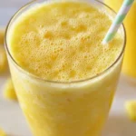 Protein pineapple turmeric smoothie in a glass with fresh ingredients