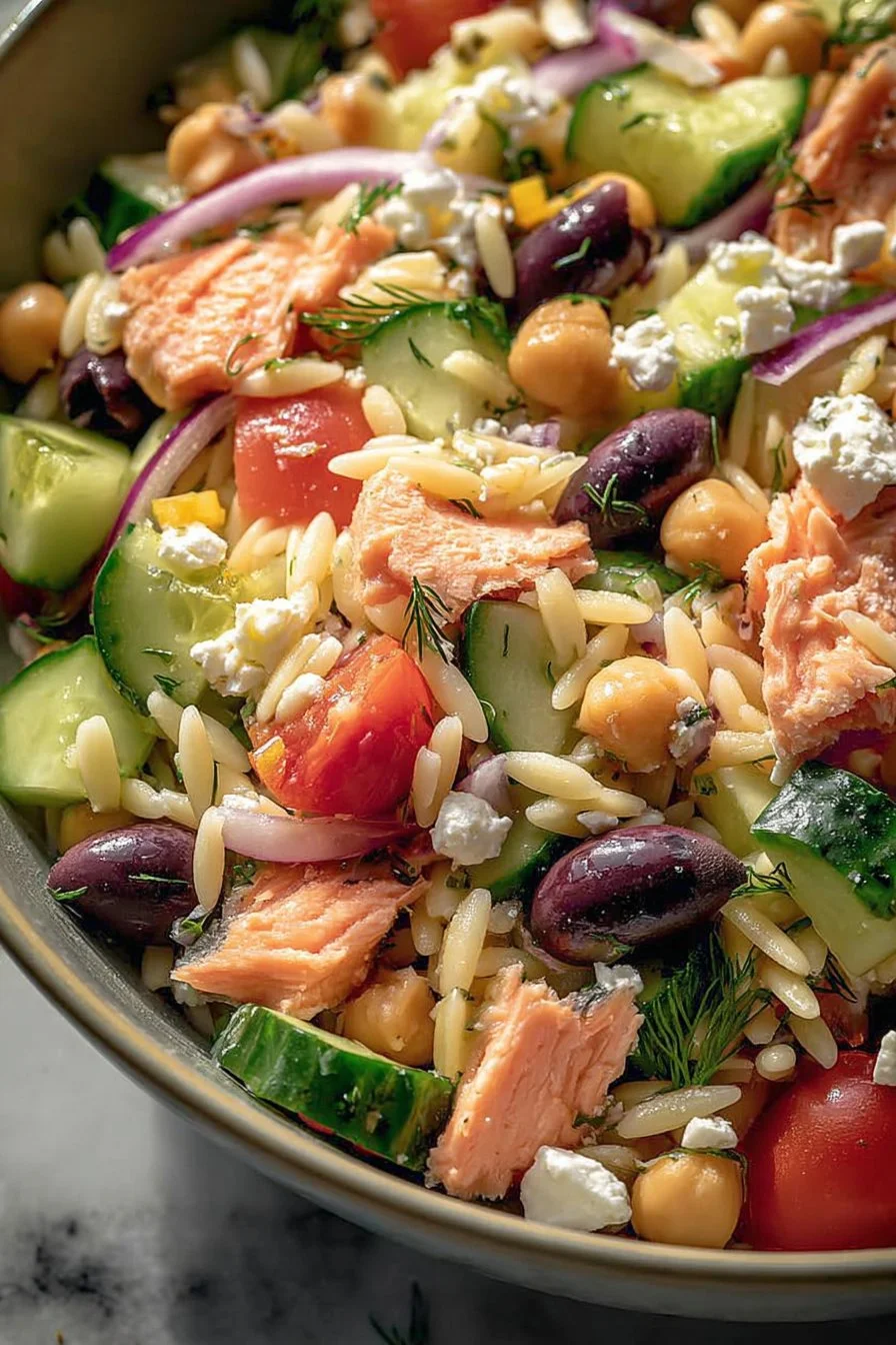 A vibrant plate of Salmon Orzo Salad, featuring fresh ingredients and colorful garnishes.
