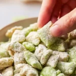 Bowl of homemade Pistachio Puppy Chow with nuts and chocolate coating